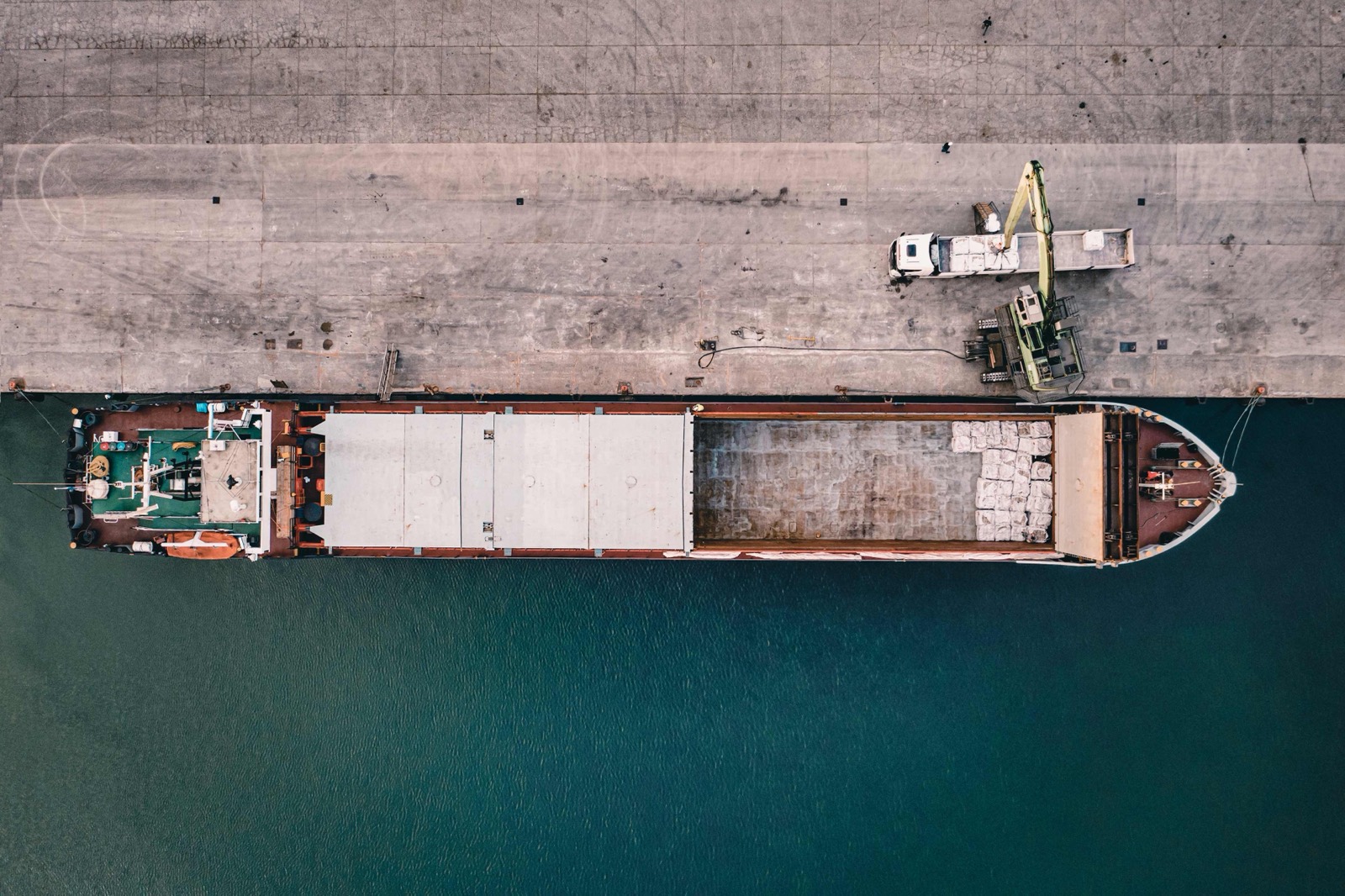Aerial top-down view of a cargo vessel loading at a berth