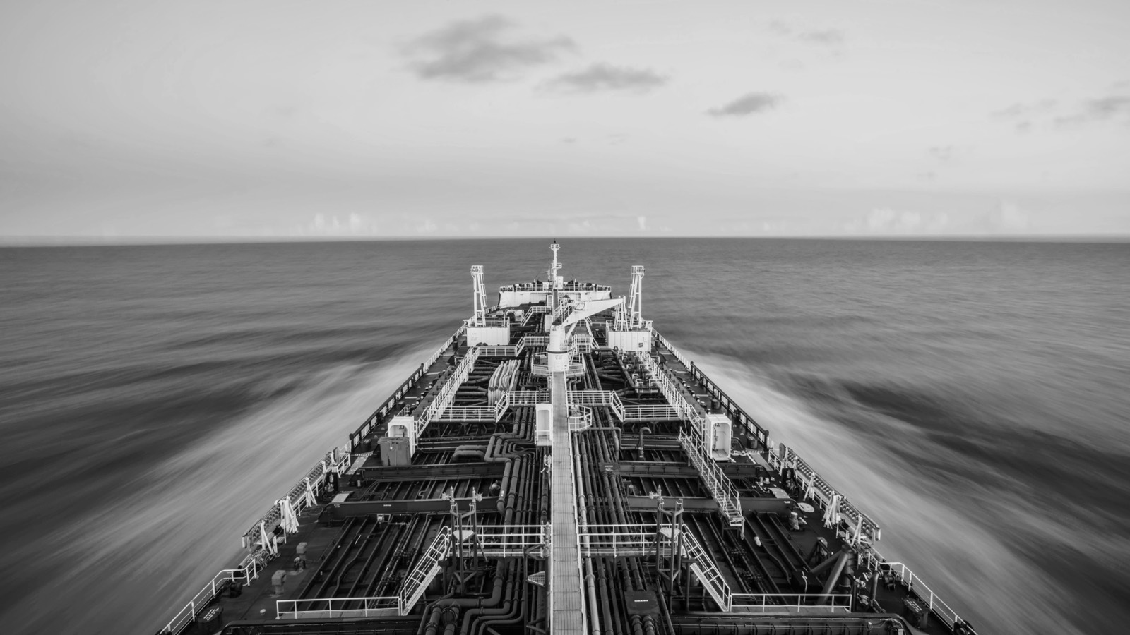 Long-exposure view along a tanker's deck to the horizon