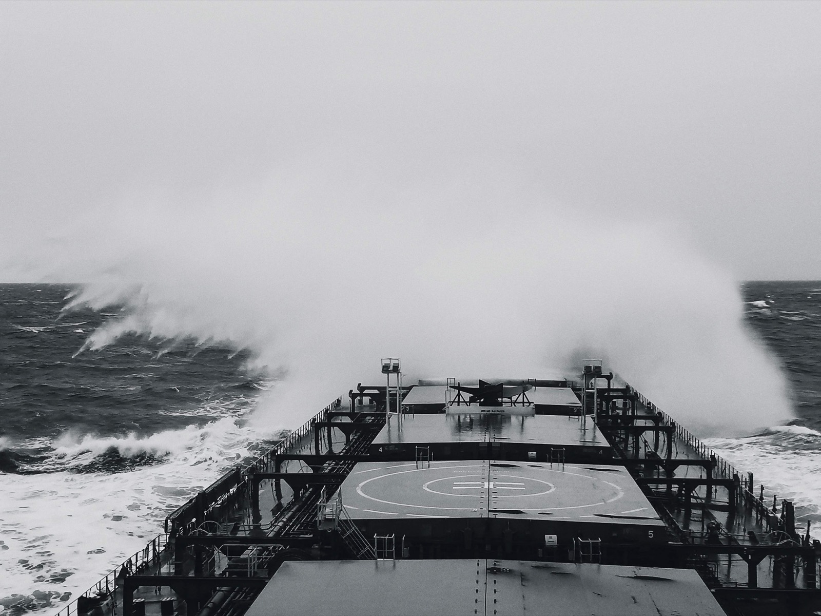 A cargo vessel taking heavy weather over the bow at sea